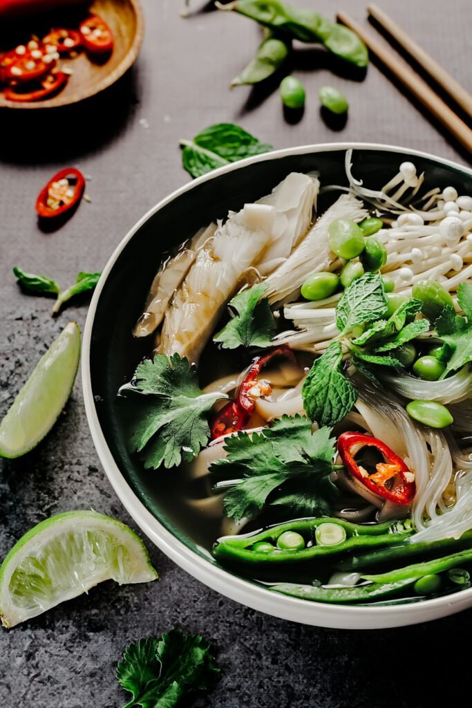 asian soup bowl with vegetables, chili, and lime